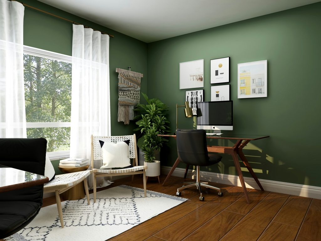 Home office with wooden desk, task chair and green walls